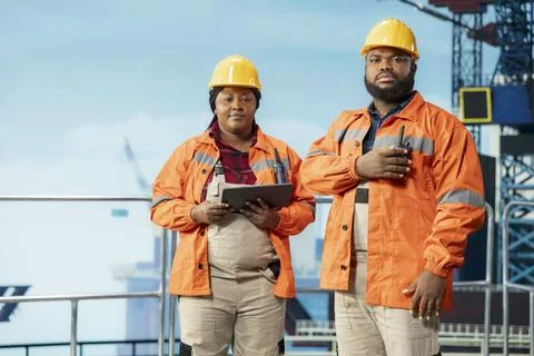 Portrait of offshore platform workers configuring derrick management systems Stock Photos