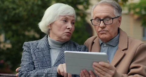 Portrait of the old Caucasian man and woman sittingon the bench and watching Stock Footage 101024352