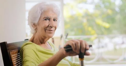 Portrait Old Lady Sitting On Rocking Chair Holding Stick Stock Photos