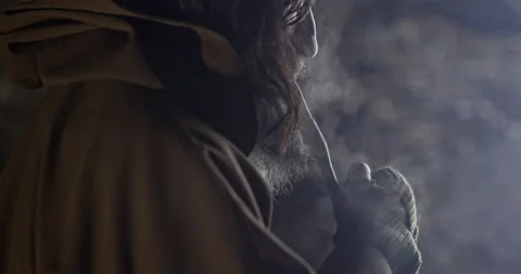Portrait of an old man with a beard in a medieval cave who actively smokes a Video stock 171487639