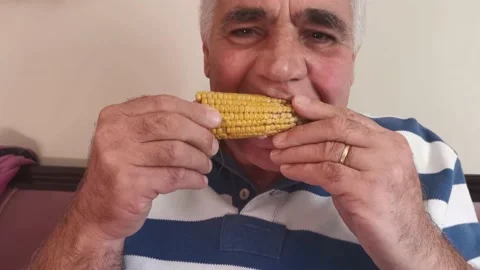 Portrait Of Old Man Eating Corn Stock Footage 142513967