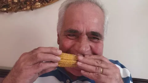 Portrait Of Old Man Eating Corn 2 Stock Footage 142631144