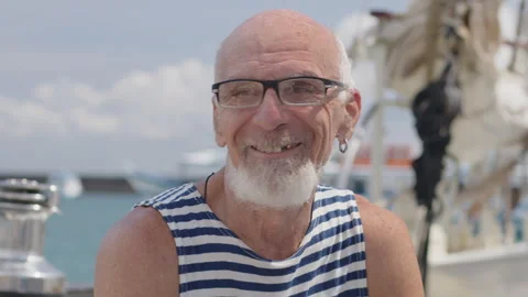 Portrait of the old man sailor with white beard and ring in the ear looking into Stock-Footage 338037565
