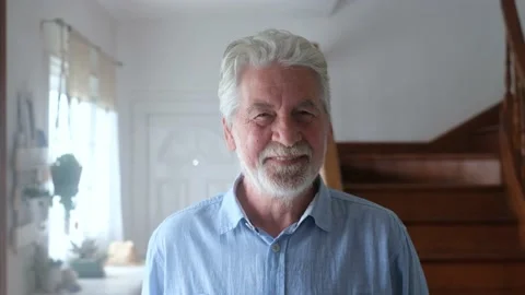 Portrait of old man smiling and looking at the camera sitting on the sofa from h Stock Footage 166244425