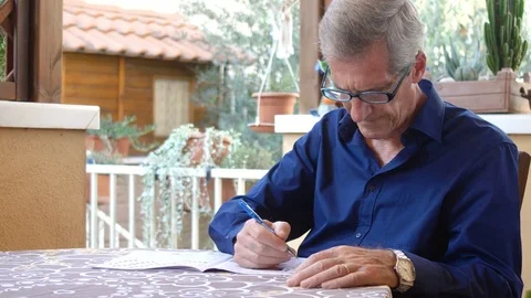 Portrait of old retired man doing cross words Stock Footage 80912807