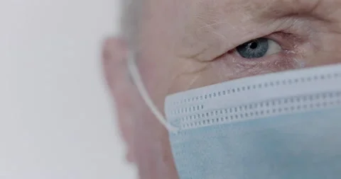 Portrait of one face part of blue-eyed senior man in medical mask on background Stock-Footage 130445080