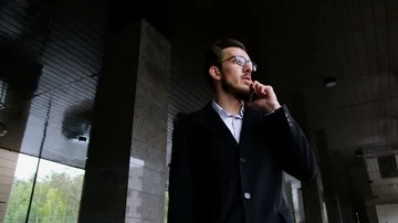 Portrait one serious manager in classic costume and in glasses stands on the Stock Footage 86081576