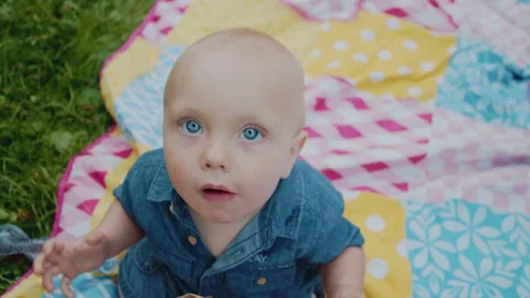 Portrait of a one year old boy chewing food in the park. Stock Footage 210248317