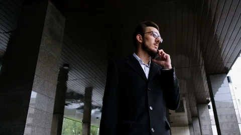 Portrait one young manager in classic costume and in glasses, answer to call and Stock Footage 86083046