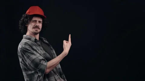 The portrait of an optimistic hipster with a red cap pointing with his index Vídeo Stock 155631941
