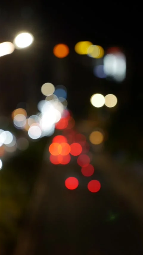 Portrait oriented night frame with defocused headlights and street illumination Stock Footage 332300850