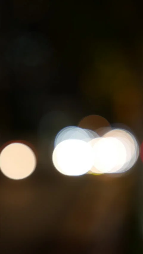 Portrait oriented night frame with distant vehicle lights and street lamps Видео 333198003