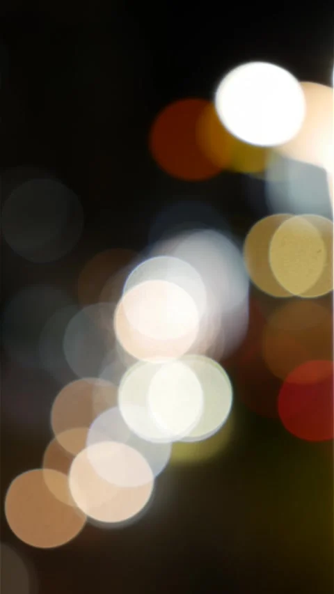 Portrait oriented night scene with blurred headlights and street lights forming 库存影片 330413169