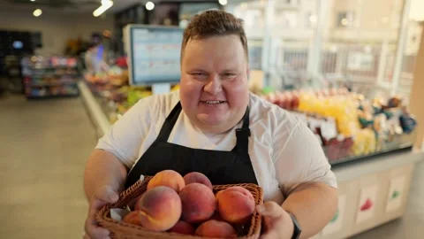 Portrait: An overweight man at a supermarket worker in a white T-shirt and a Stock-Footage 252182668