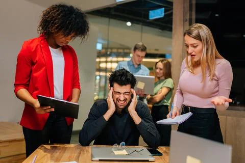 Portrait of overworked team leader under stress sitting at table with laptop Stock Photos