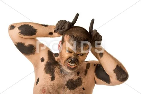 Portrait of painted man showing horns and looking at camera with aggressive grim Stock Photos