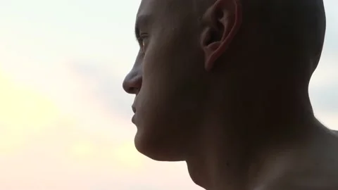 Portrait of a pensive bald monk at sunset, close-up Stock-Footage 201213286