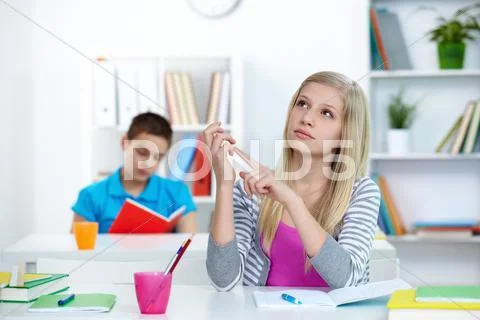 Portrait of pensive teenage blonde counting something at lesson Stock Photos