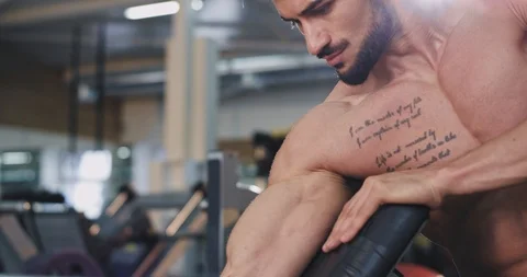 Portrait of a perfect looking fit guy concentrated working on his biceps lifting Stock Footage 114760403