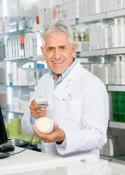 Portrait Of Pharmacist Scanning Barcode Of Shampoo Bottle 스톡 사진