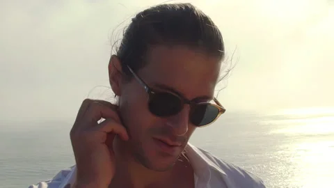 Portrait plan of a model of a man in sunglasses on a rock against  Stock Footage 168166709