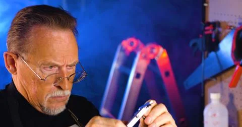 Portrait of pleasing old man working in modern industrial workshop. Stock Photos