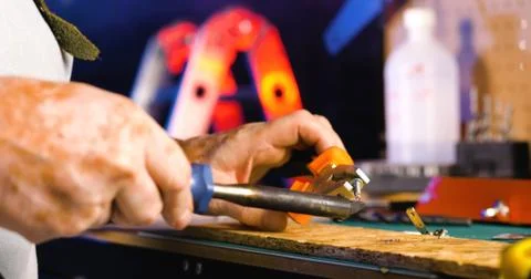 Portrait of pleasing old man working in modern industrial workshop. Stock Photos
