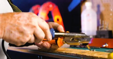Portrait of pleasing old man working in modern industrial workshop. Stock Photos