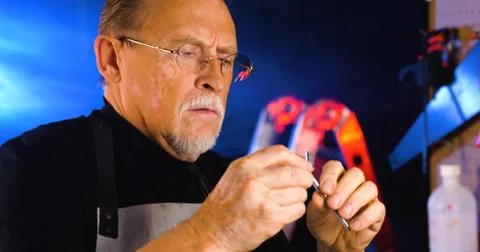 Portrait of pleasing old man working in modern industrial workshop. Stock Photos