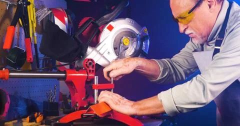 Portrait of pleasing old man working in modern industrial workshop. Stock Photos