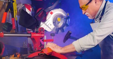 Portrait of pleasing old man working in modern industrial workshop. Stock Photos