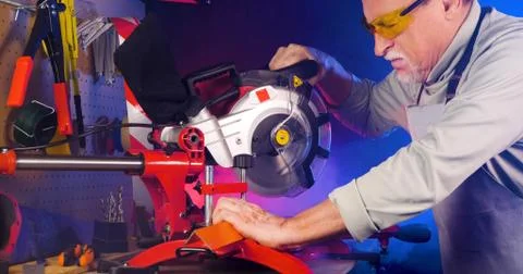 Portrait of pleasing old man working in modern industrial workshop. Stock Photos