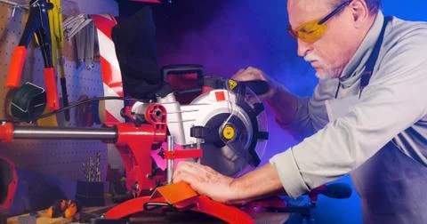 Portrait of pleasing old man working in modern industrial workshop. Stock Photos