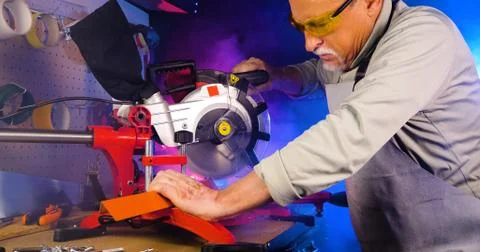 Portrait of pleasing old man working in modern industrial workshop. Stock Photos