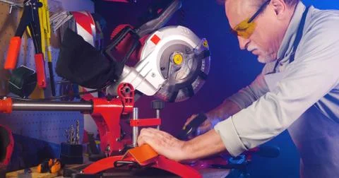 Portrait of pleasing old man working in modern industrial workshop. Stock Photos