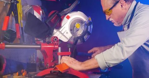 Portrait of pleasing old man working in modern industrial workshop. Stock Photos