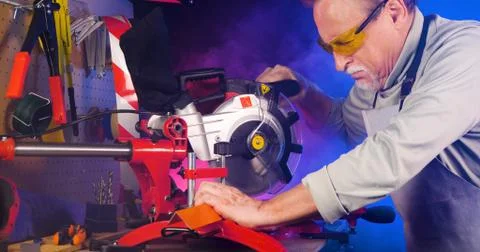 Portrait of pleasing old man working in modern industrial workshop. Stock Photos