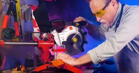 Portrait of pleasing old man working in modern industrial workshop. Stock Photos