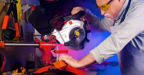Portrait of pleasing old man working in modern industrial workshop. Stock Photos