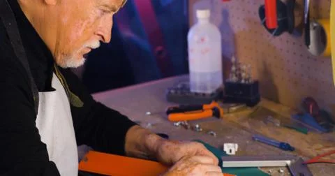 Portrait of pleasing old man working in modern industrial workshop. Stock Photos