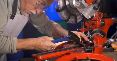 Portrait of pleasing old man working in modern industrial workshop. Stock Photos