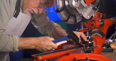 Portrait of pleasing old man working in modern industrial workshop. Stock Photos