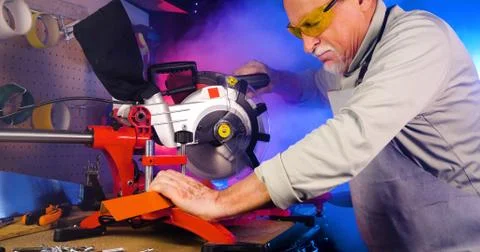 Portrait of pleasing old man working in modern industrial workshop. Stock Photos