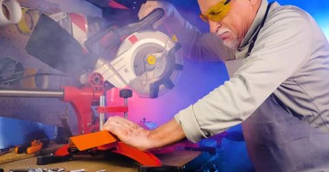 Portrait of pleasing old man working in modern industrial workshop. Stock Photos