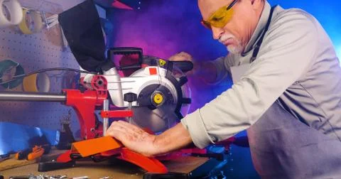Portrait of pleasing old man working in modern industrial workshop. Stock Photos