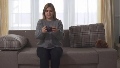 Portrait Plus Size Cute Girl Playing Video Game Sitting At Sofa In