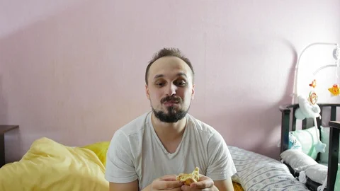 Portrait of positive hungry man making grimaces and eating a piece of pizza Stock Footage 124927985