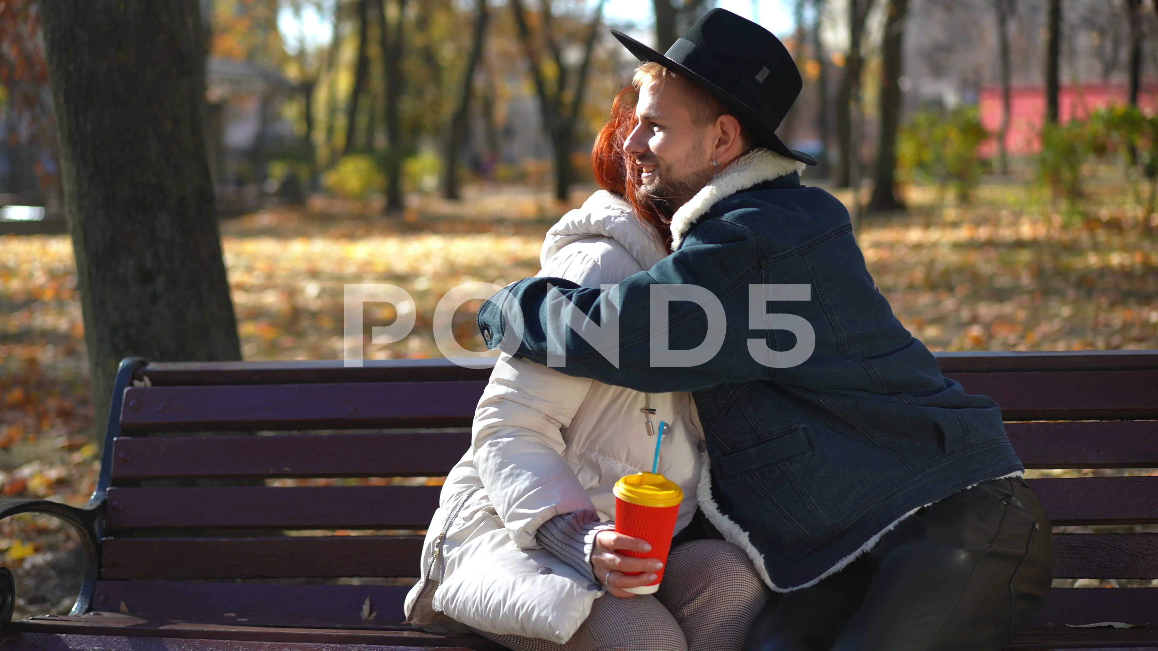 Portrait of positive redhead mature woman sitting with coffee cup on park  bench