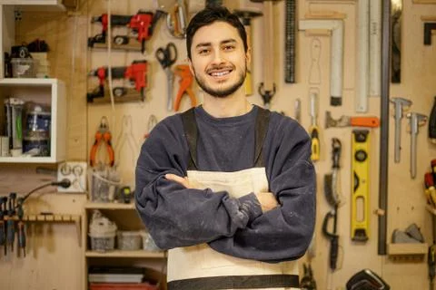 Portrait of positive smiling carpenter at work place Stock Photos