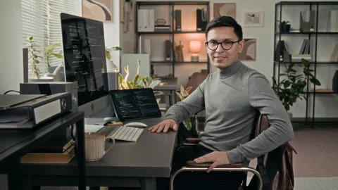 Portrait of Positive Young Software Engineer Sitting at Work Table in IT Office Stock Footage 329611746